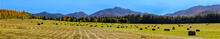 Adirondack Loj Road farm fields hay bales with Marcy, Colden and Algonquin telephoto panorama