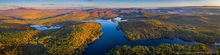 Loon Lake autumn sunrise panorama with higher altitude view of High Peaks Range to the north