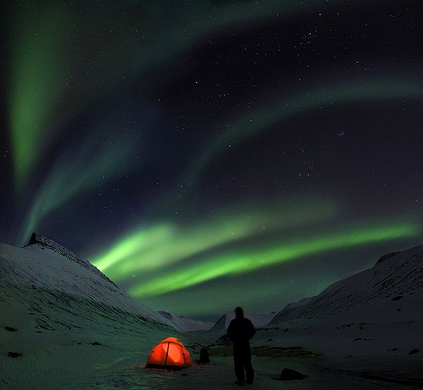 illuminated tent under the Northern Lights in a snowy valley of Iceland. but not to worry, there's no camping on this trip!