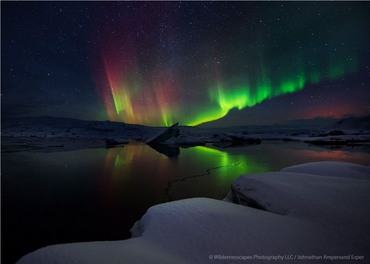 &nbsp;Aurora borealis over a wintery glacial lagoon in Iceland, with a faint glow of Holuhraun eruption on the right.