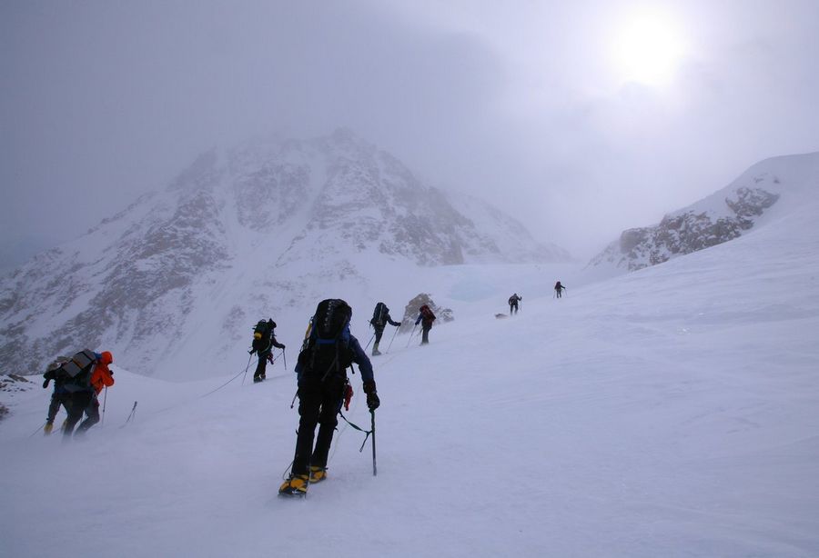 climbers struggling through blowing snow and high winds on their way up to 14,200 camp on Denali, Alaska